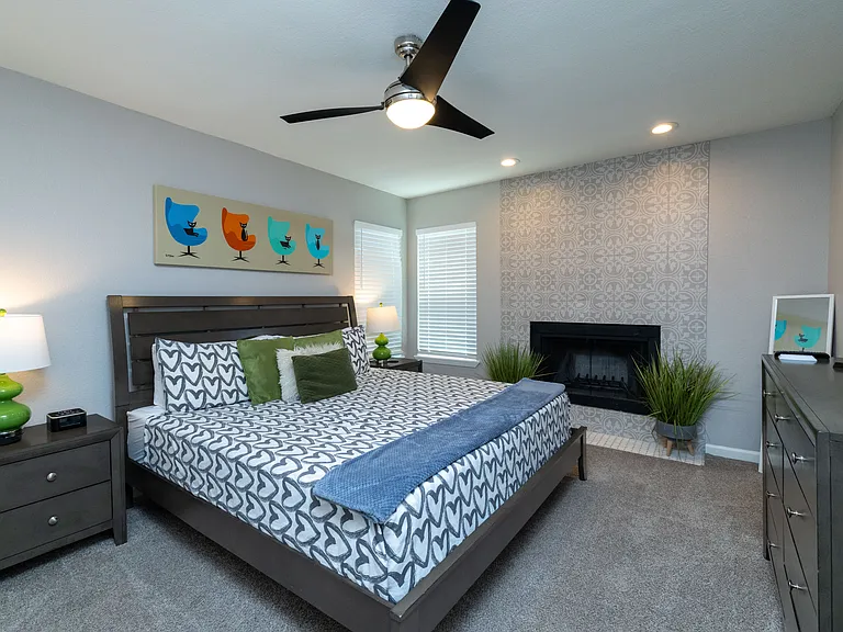 Primary bedroom with king size bed, dresser and fireplace.