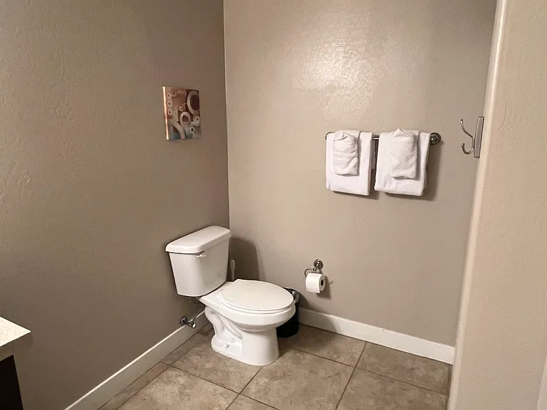 Second bathroom with one sink, toilet, and shower (no tub)