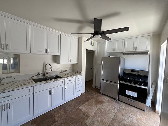 Remodeled Kitchen with brand new cabinets, countertops, sink, refrigerator, gas stove and ceiling fan