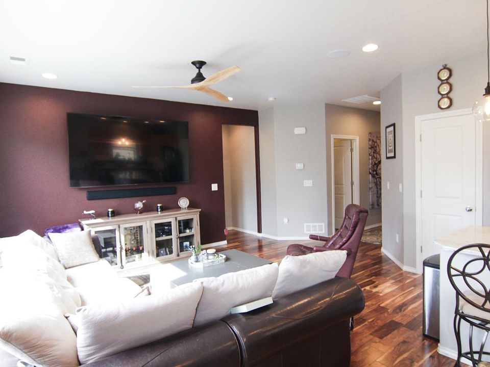 Living room view with 75-inch Smart TV, dimmer switches, and an accent wall. TV comes with the house.