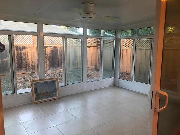 Outdoor living indoors--professional built spacious sun room with year-round sunlight with tile floors and built in ceiling fan and wall light