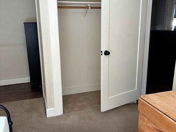 Closet in fire exit bedroom , the doors can be put back up however they are heavy to push back and forth . Small step up into kitchen and the bath just around the corner.To the left you can see where the fire exit door has vinyl flooring in front of it .