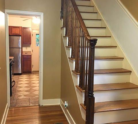 Foyer with spindle wood railing staircase.