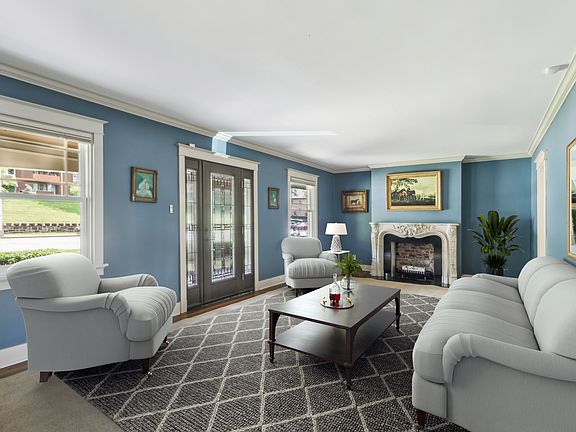 Expansive living room with a beautiful mantle (photo is staged)