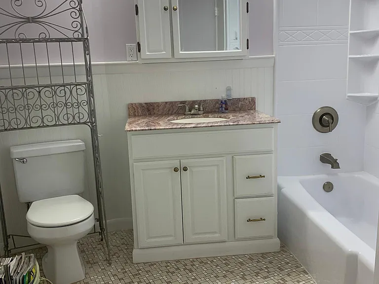 Spacious bathroom with bath and shower options.