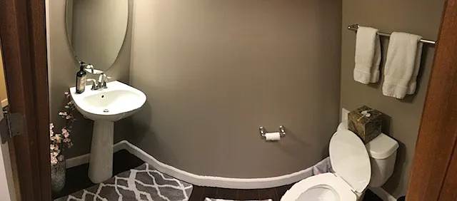 Convenient main-level powder room with pedestal sink and classic finishes.