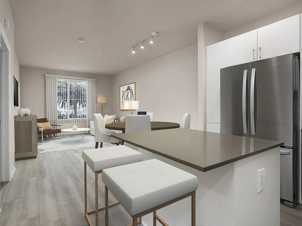 Renovated Package I kitchen with quartz countertops, white cabinetry, stainless steel appliances, hard surface vinyl plank flooring, and tile backsplash - Avalon Playa Vista
