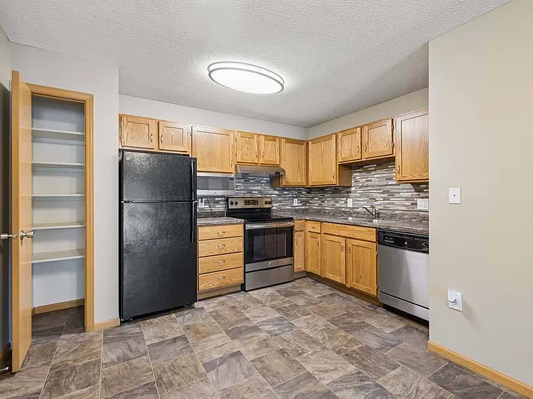 Designed for everyday ease, this welcoming kitchen pairs generous storage with classic finishes and a convenient pantry.