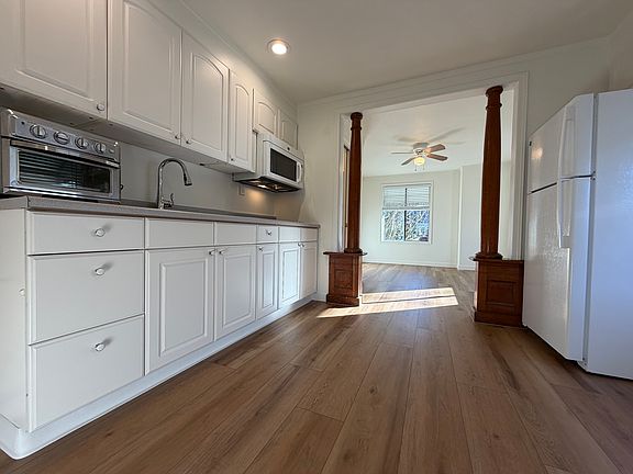 Gleaming kitchen with plenty of natural light and new microwave, cooktop, and refrigerator! Brand new hardwood flooring!