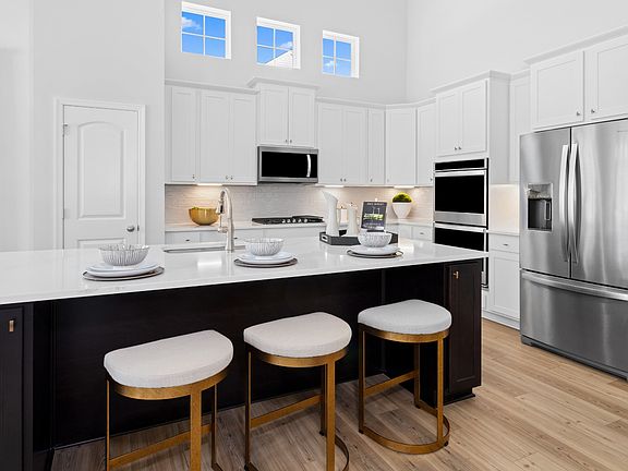 Kitchen with white cabinet and dark wood island and in a DRB Homes Aspen II model at the Deerfield