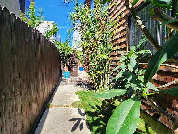 Two story with lush vegetation.
