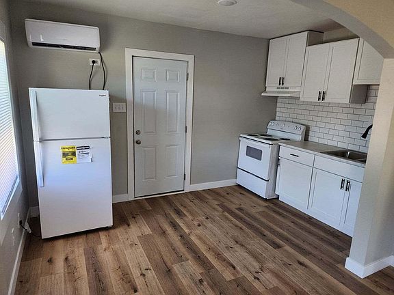 Kitchen view, new refrigerator, new cabinets, stove, sink, tile, flooring.