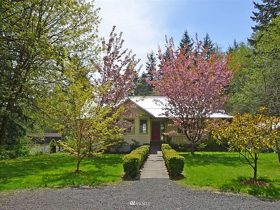 Front of house, with lined walkway and beautiful flowering trees