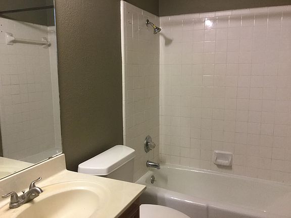 Hall bath has cast iron tub and ceramic tile shower walls.