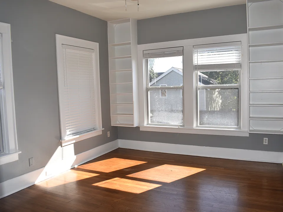 Master bedroom with built in shelving and plenty of natural lighting.