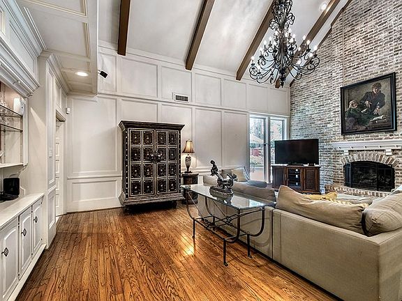 Den with vaulted, beamed ceiling and built-in lighted cabinet is open to Kitchen