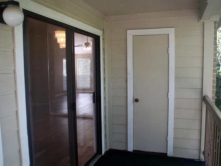 Outside tree lined covered patio with storage closet