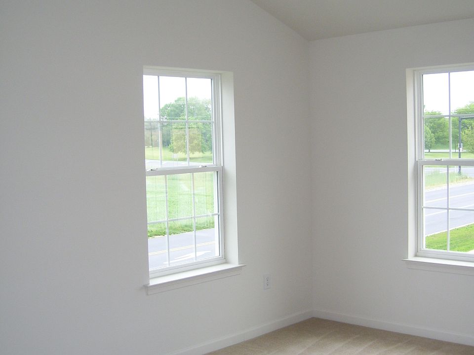Primary bedroom with vaulted ceiling and fan.