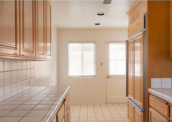 Kitchen with custom refrigerator and pantry on the side next to the refrigerator. And view of the breakfast nook area.