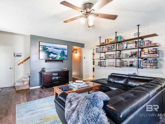 Living room featuring ceiling fan and dark hardwood / wood-style floors