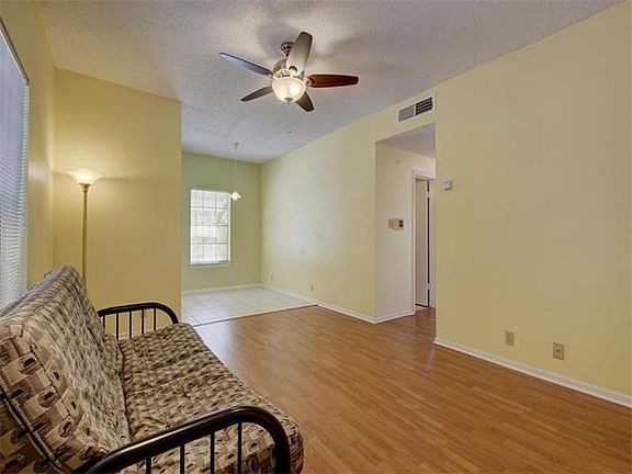 The living room has laminate floors and a large window.