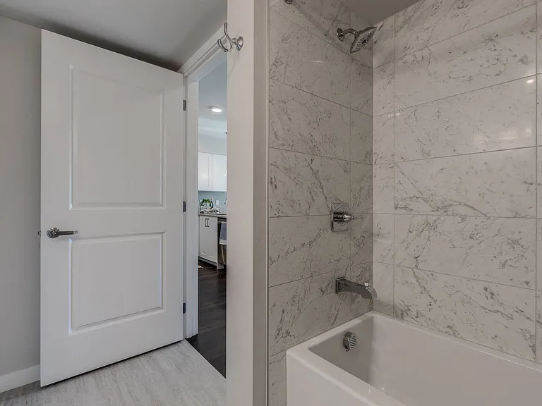 Our bathrooms include floor to ceiling, surround tiling in the bathtub and shower, and light-grey wood-style vinyl flooring for a modern and stylish look.