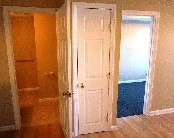 view from kitchen into bath and carpeted bedroom