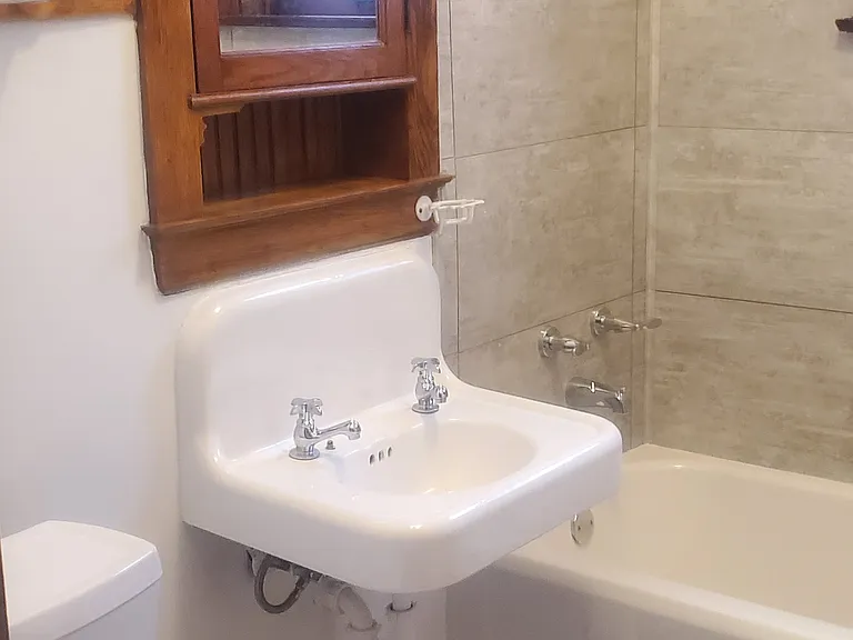 Bathroom: Newly refinished, vintage cast iron tub & sink. Vintage wood medicine cabinet, small new wall cabinet (not seen in pic), shower. New wall tile & flooring. Bright.