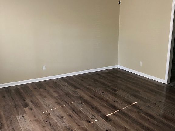 Large living room with hardwood floors and ornamental ceiling fan