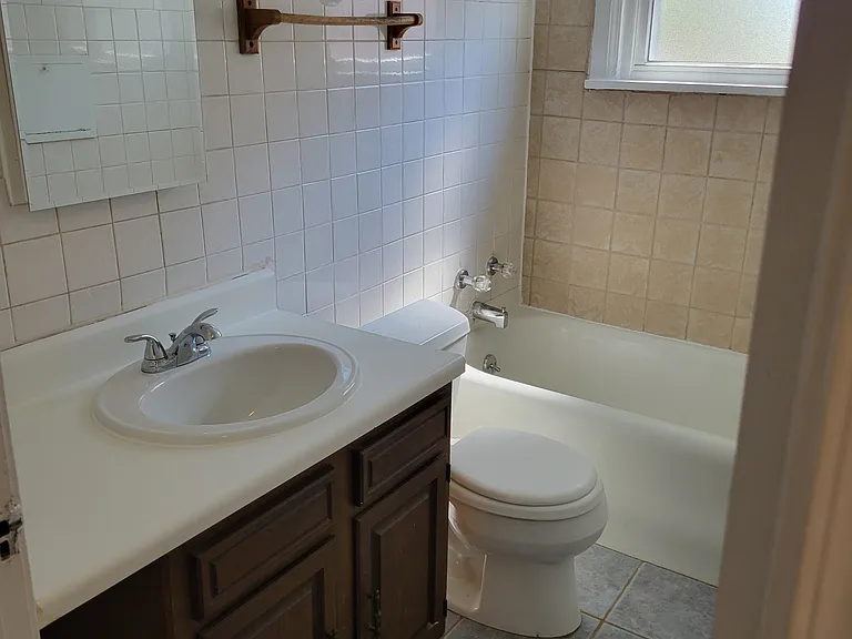 Bathroom with new medicine cabinet, sink, faucet and window.