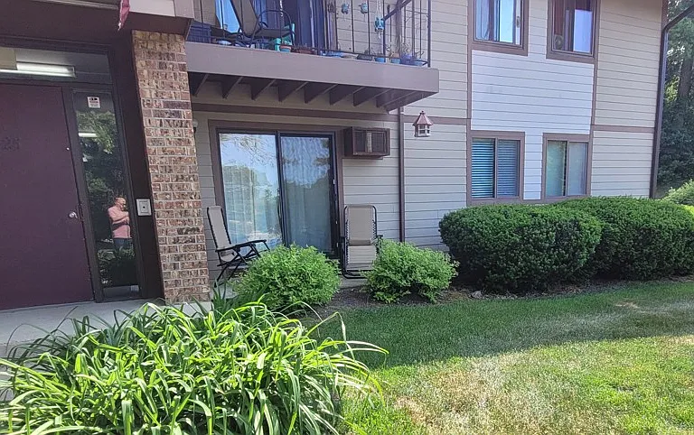 Unit close-up. Door on left allows entry to building. Glass double door allows access to porch and front lawn.