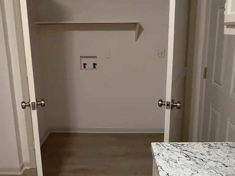 Seprate laundry room with washer/dryer hookups and extra space for storage - convenient and tucked away for a clean, organized home,