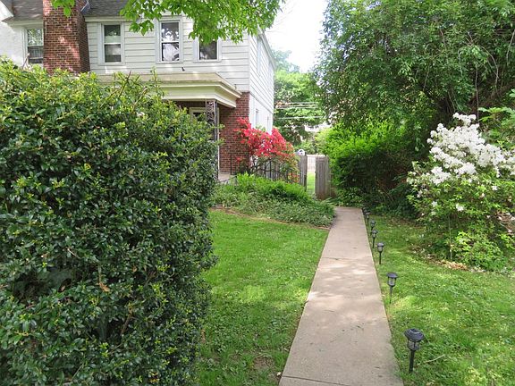 View of the property from the sidewalk. Lights line the pathway to the front door.
