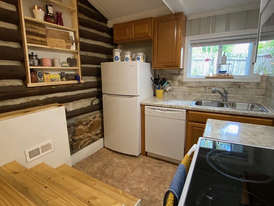 Kitchen 1/2 level down from living room. Appliances include Fridge, dishwasher and over-the-range microwave. A door from the kitchen leads to the shared laundry room.