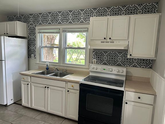 Freshly renovated kitchen, with gorgeous tiles that add a pop of color and add to this homes farm house feel.