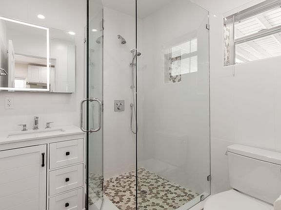 Beautiful bathroom with shower with glass door, new vanity & medicine cabinet that lights up.