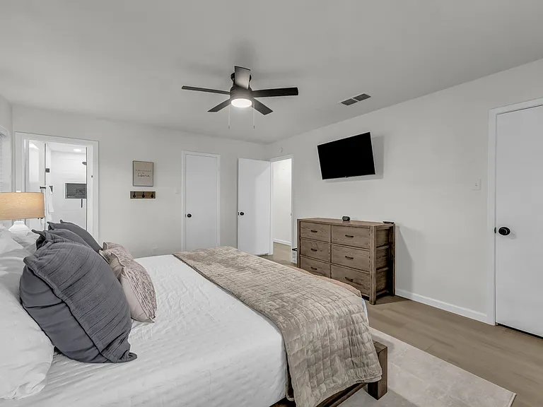 Primary bedroom with comfy king size bed and plenty of extra pillows, blankets and sheets. Closet with hangers and dresser ready for you to stay a while! Private bathroom off of primary bedroom.