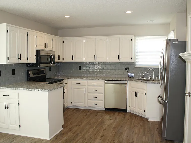 Everything in this stunning kitchen has been redone -- newly painted cabinets, tile backsplash, granite countertops, and appliances. Oh yea, don't forget the new light fixtures, cabinet hardware, and door hardware and blinds. . . and windows! And floori