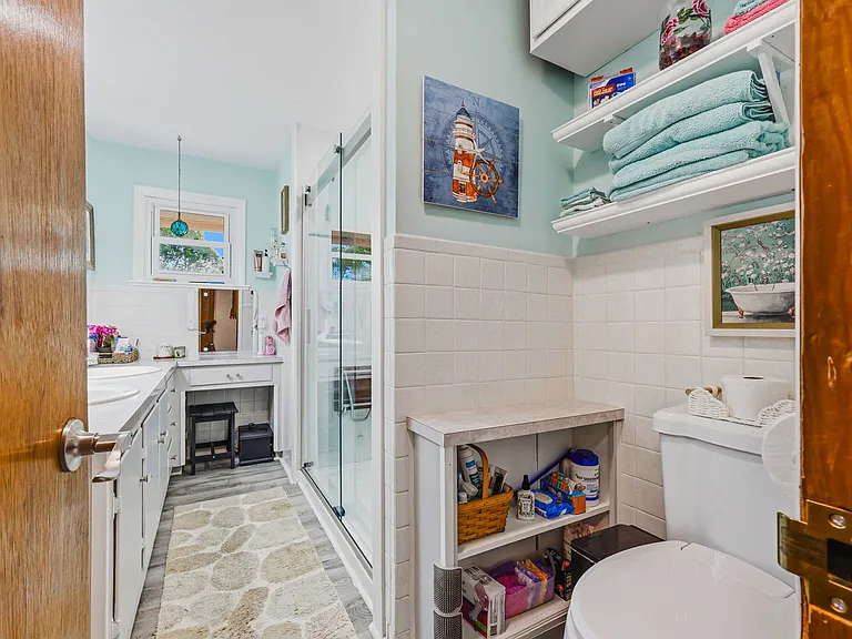 MAIN LEVEL Full Bath with Chair Height Commode, Double Sinks, Vanity, Walk-in Shower, and Ample Storage. (Bedrooms to left, Main Living Areas to right) 
NOT SHOWN, Child's Bedroom/Office/Den behind camera)