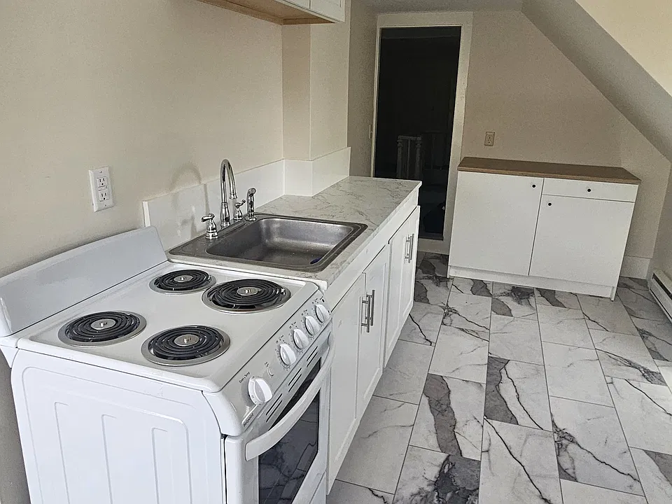 Partial view of the kitchen area with door at rear leading to the central hallway