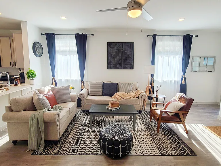Open-concept living area with two sofas, accent chair, and a breakfast bar that connects directly to the kitchen.