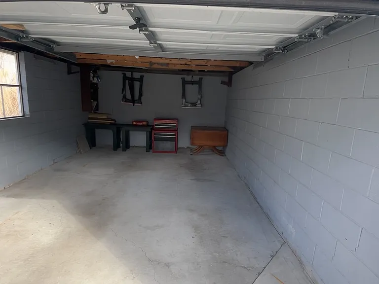 Clean garage interior with room for light outdoor storage. Overhead lighting and electrical outlet.