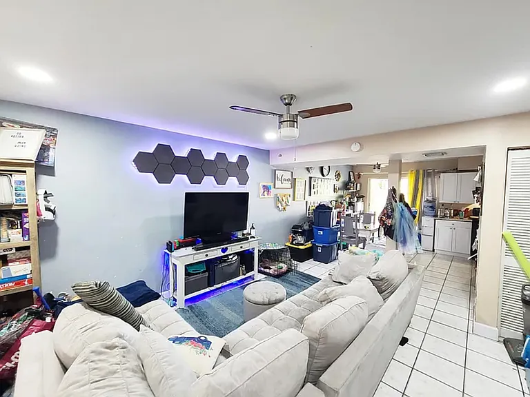 The living room at 3609 Townhouse Ct, West Palm Beach, FL 33407, offers a spacious and inviting area that seamlessly connects to the well-appointed kitchen. This open-concept design is ideal for both entertaining guests and everyday living.
