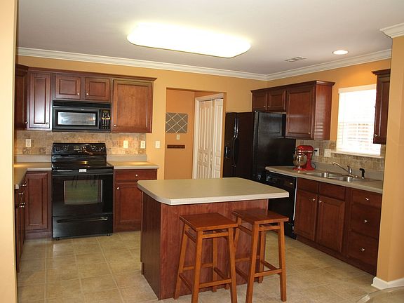 Kitchen has travertine backspash and under cabinet lighting