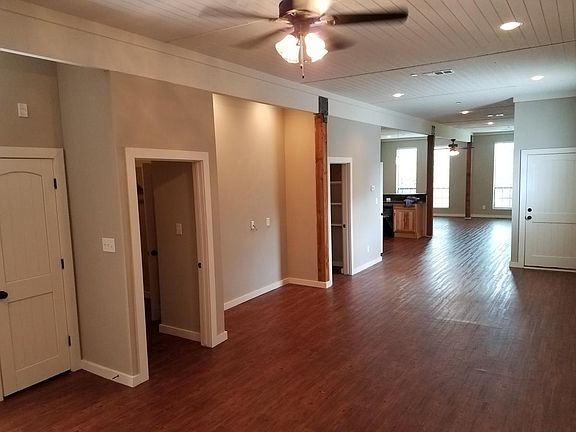 Forward view from back wall, entrance (right), on left is a closet, laundry room, bathroom, kitchen (left), front windows