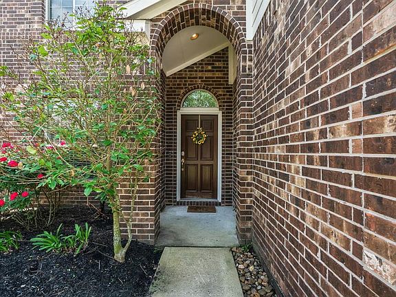 Walkway leading to a wood front door