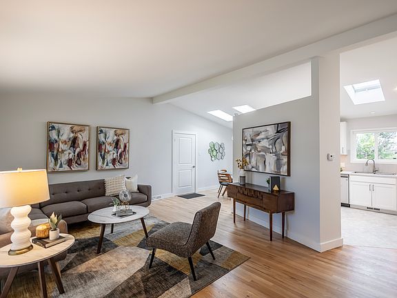 Vaulted living room, dining room with skylights, large kitchen, hardwood floors, fresh paint throughout