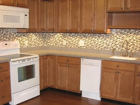Large custom kitchen with solid wood cabinets and granite-look solid surface counters and undermount sink