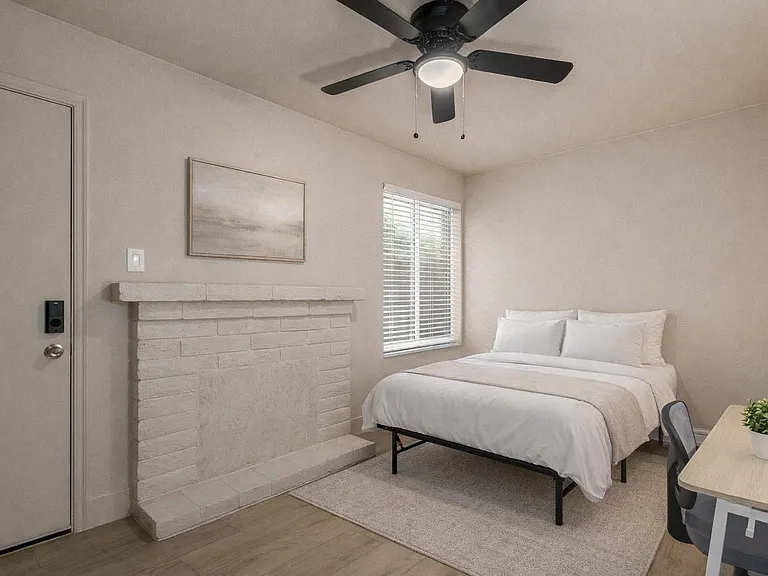 Queen bed, desk, chair, lamp, fan, closet. Bedding and rug are virtually staged.
