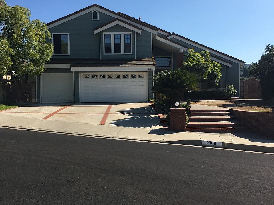 front view of house new paint, 3 car garage and driveway par